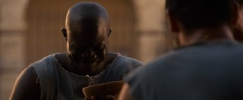 Movie still from “Gladiator” (2000), directed by Ridley Scott – A man holding a bowl in his hands; Close Up shot, Over the shoulder angle