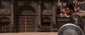 Movie still from “Gladiator” (2000), directed by Ridley Scott – A group of men standing in front of a building; Extreme Wide shot, Over the shoulder angle