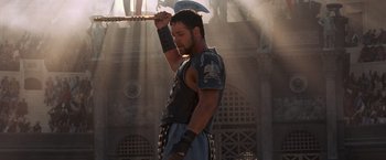 Movie still from “Gladiator” (2000), directed by Ridley Scott – A man holding a sword in his hand; Medium shot, Low angle