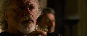 Movie still from “Gladiator” (2000), directed by Ridley Scott – An older man holding a glass of wine in front of another man; Close Up shot, Over the shoulder angle