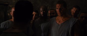 Movie still from “Gladiator” (2000), directed by Ridley Scott – A group of men standing next to each other in the dark; Close Up shot, Over the shoulder angle