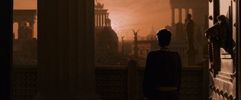 Movie still from “Gladiator” (2000), directed by Ridley Scott – A man standing in front of a window looking out at a sunset; Extreme Wide shot, Low angle