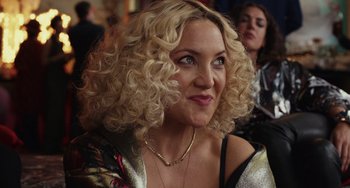 Movie still from “Glass Onion” (2022), directed by Rian Johnson – A person with curly blonde hair; Close Up shot, Over the shoulder angle