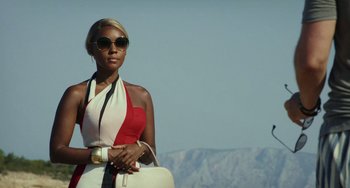 Movie still from “Glass Onion” (2022), directed by Rian Johnson – A woman wearing sunglasses and holding a white purse; Medium shot, Low angle