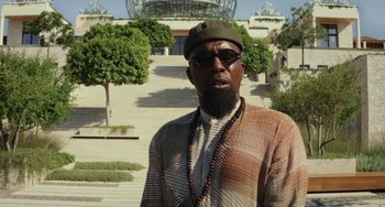 Movie still from “Glass Onion” (2022), directed by Rian Johnson – A man with a beard wearing sunglasses and a hat; Close Up shot, Low angle