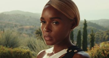 Movie still from “Glass Onion” (2022), directed by Rian Johnson – A person wearing a black and white shirt; Close Up shot, Over the shoulder angle