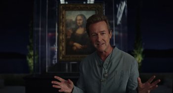 Movie still from “Glass Onion” (2022), directed by Rian Johnson – A man standing in front of a painting of a woman; Medium shot, Over the shoulder angle