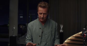 Movie still from “Glass Onion” (2022), directed by Rian Johnson – A man in a green jacket is standing in front of a window; Medium shot, Over the shoulder angle