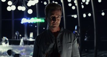 Movie still from “Glass Onion” (2022), directed by Rian Johnson – A man standing in front of lights at night; Close Up shot, Over the shoulder angle