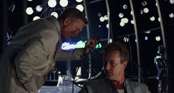 Movie still from “Glass Onion” (2022), directed by Rian Johnson – Two men are working together on a project; Medium shot, Over the shoulder angle