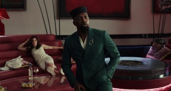 Movie still from “Glass Onion” (2022), directed by Rian Johnson – A man in a green suit and a woman in a white dress; Medium shot, Low angle