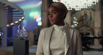 Movie still from “Glass Onion” (2022), directed by Rian Johnson – A woman in a white jacket and a white shirt; Close Up shot, Over the shoulder angle