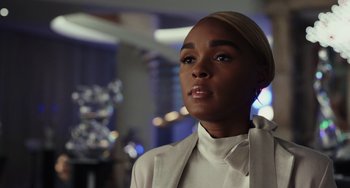 Movie still from “Glass Onion” (2022), directed by Rian Johnson – A woman in a white jacket looking to her left; Close Up shot, Over the shoulder angle