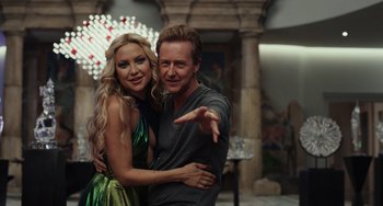 Movie still from “Glass Onion” (2022), directed by Rian Johnson – A man and a woman posing for a picture; Medium shot, Low angle