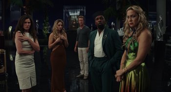 Movie still from “Glass Onion” (2022), directed by Rian Johnson – A group of people standing in front of a mirror; Medium shot, Over the shoulder angle