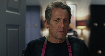 Movie still from “Glass Onion” (2022), directed by Rian Johnson – A person wearing an apron; Close Up shot, Over the shoulder angle