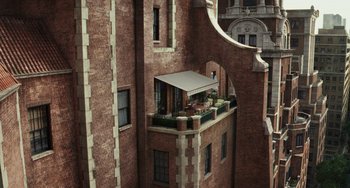 Movie still from “Glass Onion” (2022), directed by Rian Johnson – An old building with a balcony and a balcony awning; Extreme Wide shot, Overhead angle