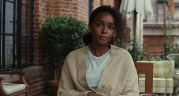 Movie still from “Glass Onion” (2022), directed by Rian Johnson – A young woman wearing a white sweater and a blue shirt; Close Up shot, Over the shoulder angle
