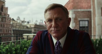 Movie still from “Glass Onion” (2022), directed by Rian Johnson – A person wearing a suit and tie; Close Up shot, Over the shoulder angle