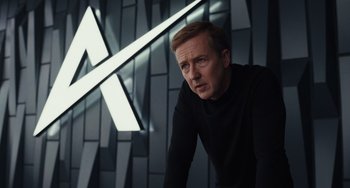 Movie still from “Glass Onion” (2022), directed by Rian Johnson – A man in black shirt leaning on a wall; Medium shot, Low angle