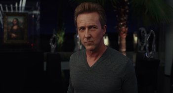 Movie still from “Glass Onion” (2022), directed by Rian Johnson – A person wearing a gray shirt; Close Up shot, Over the shoulder angle