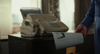 Movie still from “Glass Onion” (2022), directed by Rian Johnson – An office phone sitting on top of a desk; Close Up shot, High angle