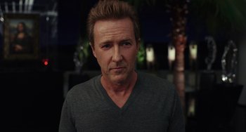 Movie still from “Glass Onion” (2022), directed by Rian Johnson – A person wearing a gray t - shirt; Close Up shot, Low angle