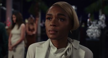 Movie still from “Glass Onion” (2022), directed by Rian Johnson – A person wearing a suit; Close Up shot, Over the shoulder angle