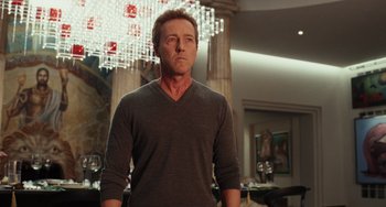 Movie still from “Glass Onion” (2022), directed by Rian Johnson – A man standing in front of a chandelier in a room; Medium shot, Low angle