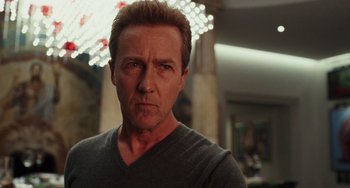 Movie still from “Glass Onion” (2022), directed by Rian Johnson – A person wearing a gray t - shirt; Close Up shot, Low angle