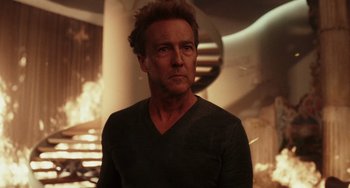 Movie still from “Glass Onion” (2022), directed by Rian Johnson – A person wearing a black shirt; Close Up shot, Over the shoulder angle