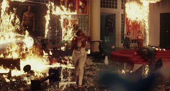 Movie still from “Glass Onion” (2022), directed by Rian Johnson – A woman in a white dress is in a room on fire; Wide shot, High angle