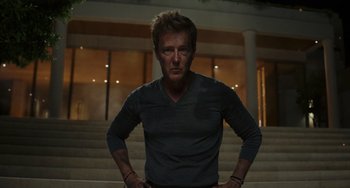 Movie still from “Glass Onion” (2022), directed by Rian Johnson – A man standing in front of some stairs; Medium shot, Low angle