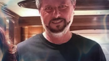 Movie still from “God Forbid” (2022), directed by Billy Corben – A person wearing a black shirt; Close Up shot, High angle