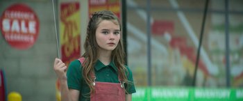 Movie still from “God Is a Bullet” (2023), directed by Nick Cassavetes – A young girl in a green shirt and pink apron; Close Up shot, Over the shoulder angle