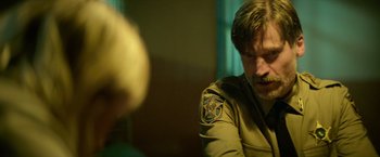 Movie still from “God Is a Bullet” (2023), directed by Nick Cassavetes – A man sitting in front of another man in a room; Close Up shot, Over the shoulder angle