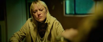 Movie still from “God Is a Bullet” (2023), directed by Nick Cassavetes – A woman with tattoos on her face sitting in a room; Close Up shot, Low angle