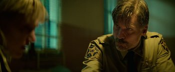 Movie still from “God Is a Bullet” (2023), directed by Nick Cassavetes – A person wearing a uniform; Close Up shot, Over the shoulder angle