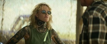 Movie still from “God Is a Bullet” (2023), directed by Nick Cassavetes – A woman with a skull tattoo on her neck; Close Up shot, Over the shoulder angle
