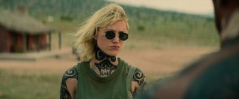 Movie still from “God Is a Bullet” (2023), directed by Nick Cassavetes – A woman with tattoos on her arms and neck; Close Up shot, Over the shoulder angle