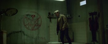 Movie still from “God Is a Bullet” (2023), directed by Nick Cassavetes – A man holding a gun while standing in a room; Medium shot, High angle