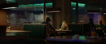 Movie still from “God Is a Bullet” (2023), directed by Nick Cassavetes – A man and a woman sitting at a table in a restaurant; Wide shot, Over the shoulder angle