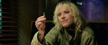 Movie still from “God Is a Bullet” (2023), directed by Nick Cassavetes – A woman holding a cigarette in her right hand; Close Up shot, Over the shoulder angle