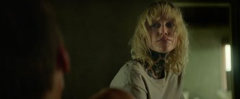 Movie still from “God Is a Bullet” (2023), directed by Nick Cassavetes – A woman with a tattoo on her neck looking into a mirror; Close Up shot, Over the shoulder angle