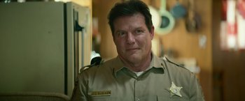 Movie still from “God Is a Bullet” (2023), directed by Nick Cassavetes – A person wearing a police uniform; Close Up shot, Low angle