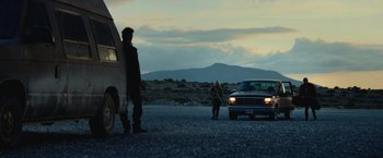 Movie still from “God Is a Bullet” (2023), directed by Nick Cassavetes – A man and a woman standing in front of a car; Wide shot, Low angle