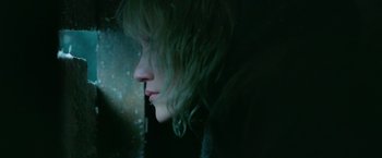 Movie still from “God Is a Bullet” (2023), directed by Nick Cassavetes – A woman with blonde hair looking out a window at night; Close Up shot, Overhead angle