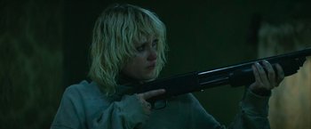 Movie still from “God Is a Bullet” (2023), directed by Nick Cassavetes – A woman holding a gun in a dark room; Close Up shot, Low angle