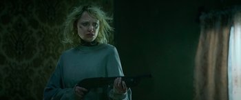 Movie still from “God Is a Bullet” (2023), directed by Nick Cassavetes – A woman holding a gun while standing in the dark; Close Up shot, Low angle