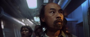 Movie still from “Godzilla” (1998), directed by Roland Emmerich – A person with long hair on a train; Close Up shot, Low angle